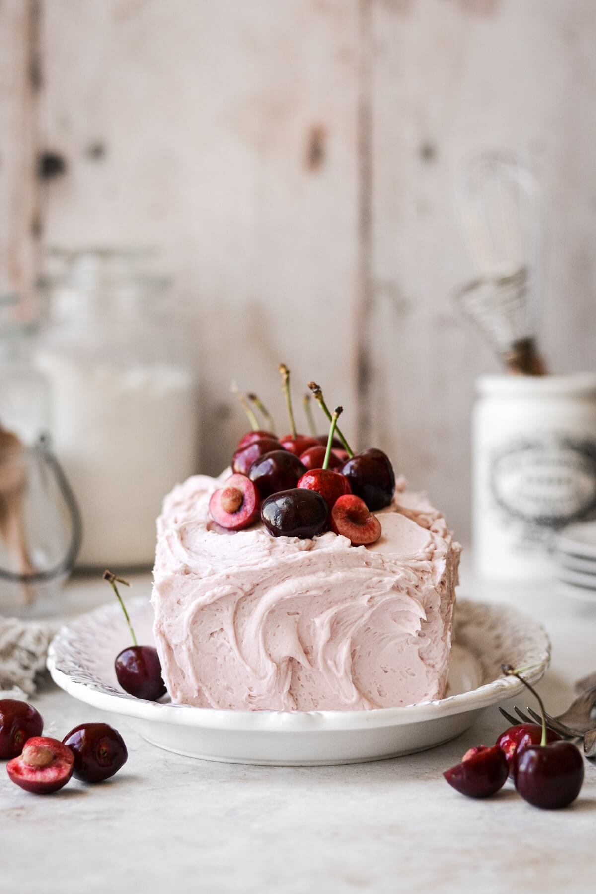 Loaf cake with cherry buttercream and fresh cherries.
