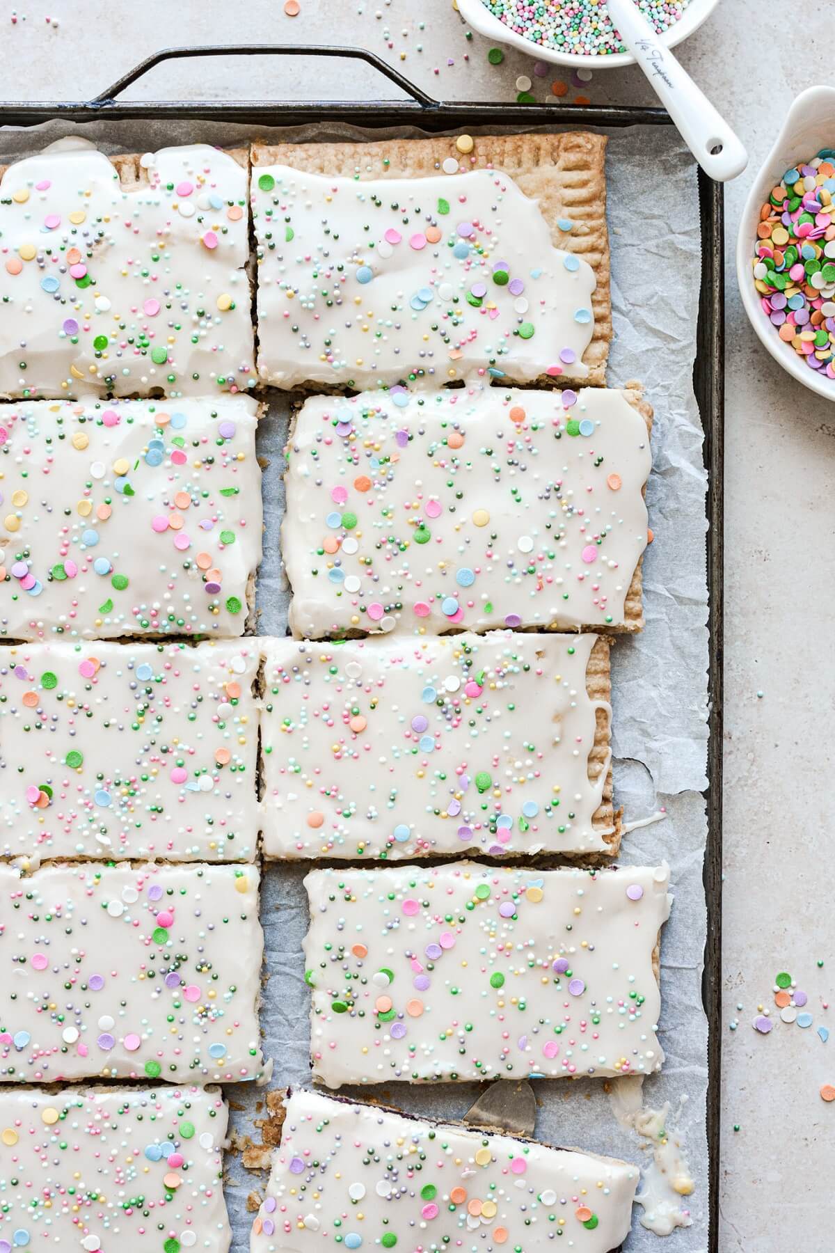 Blueberry pop tarts with vanilla icing and sprinkles.