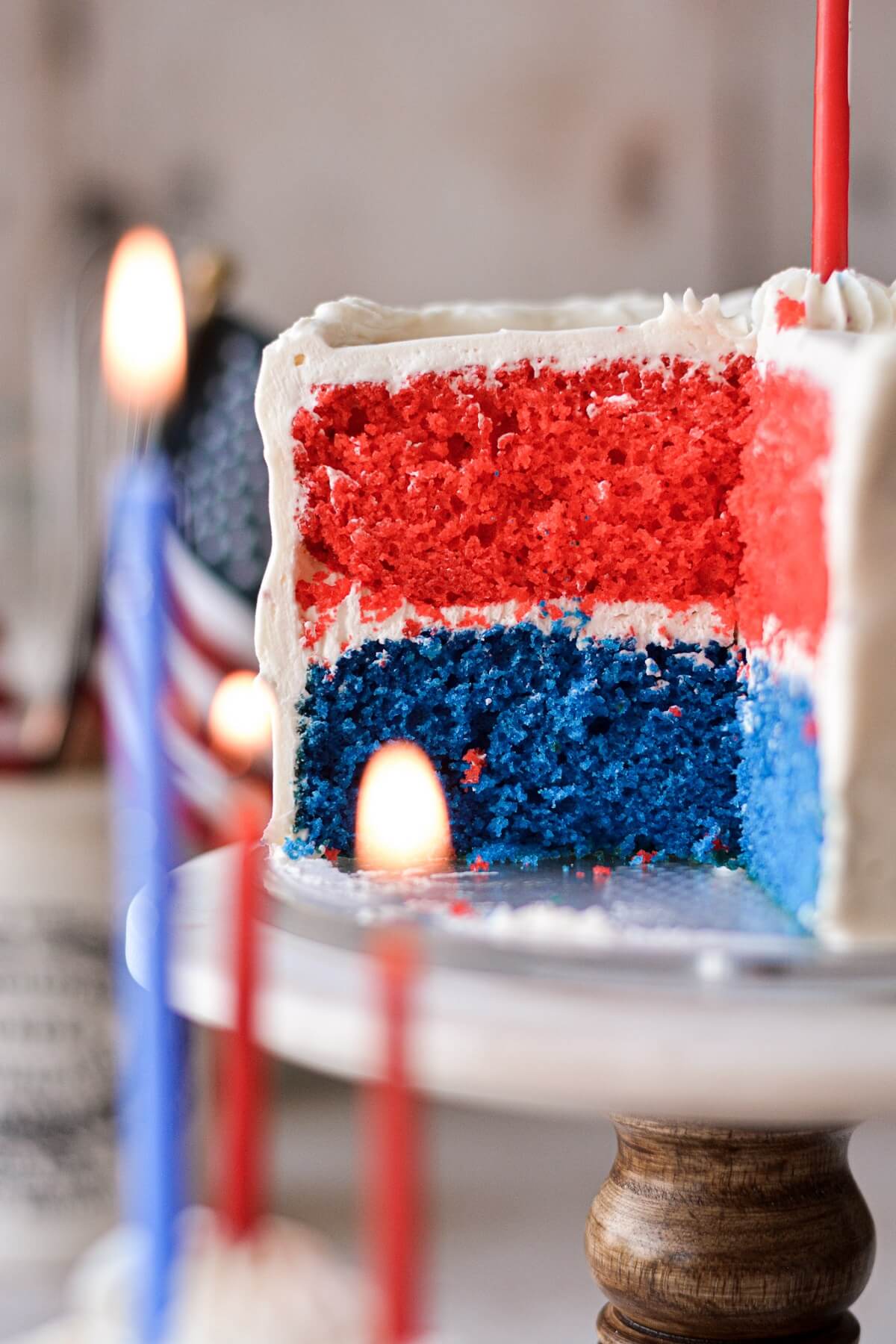 Red, white and blue cake with a slice cut.