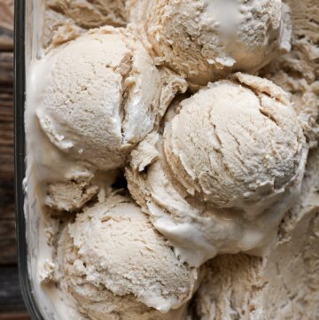 Scoops of White Russian ice cream in a glass container.
