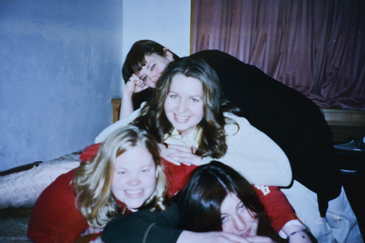Friends piled on a bed.
