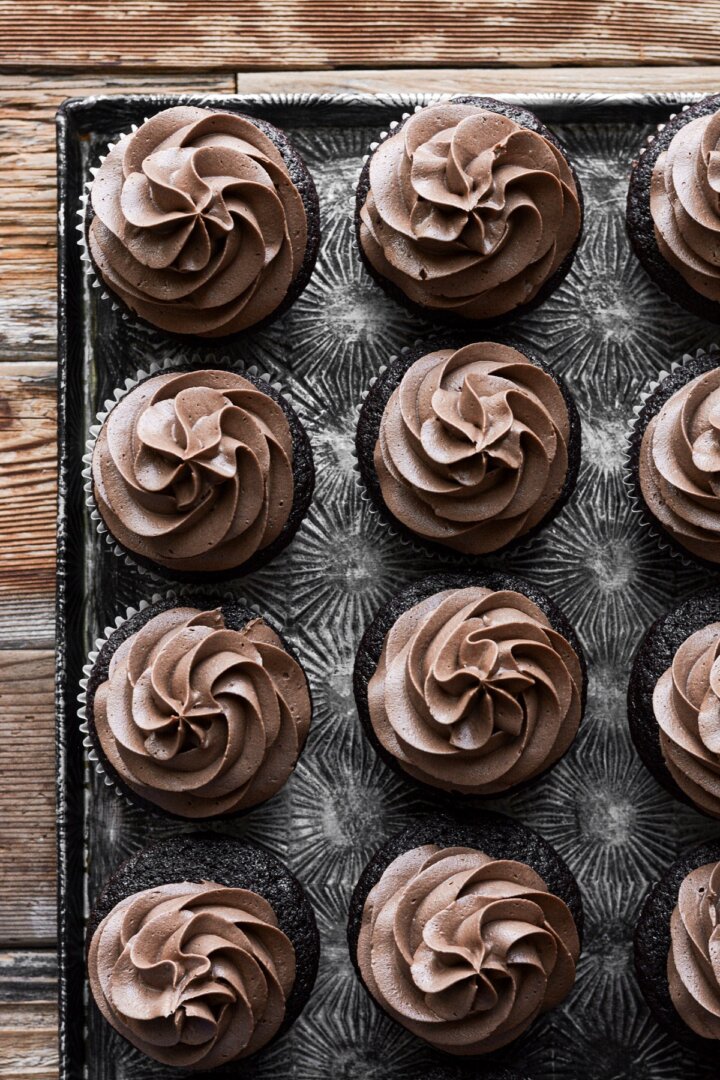 Espresso buttercream piped onto chocolate cupcakes.