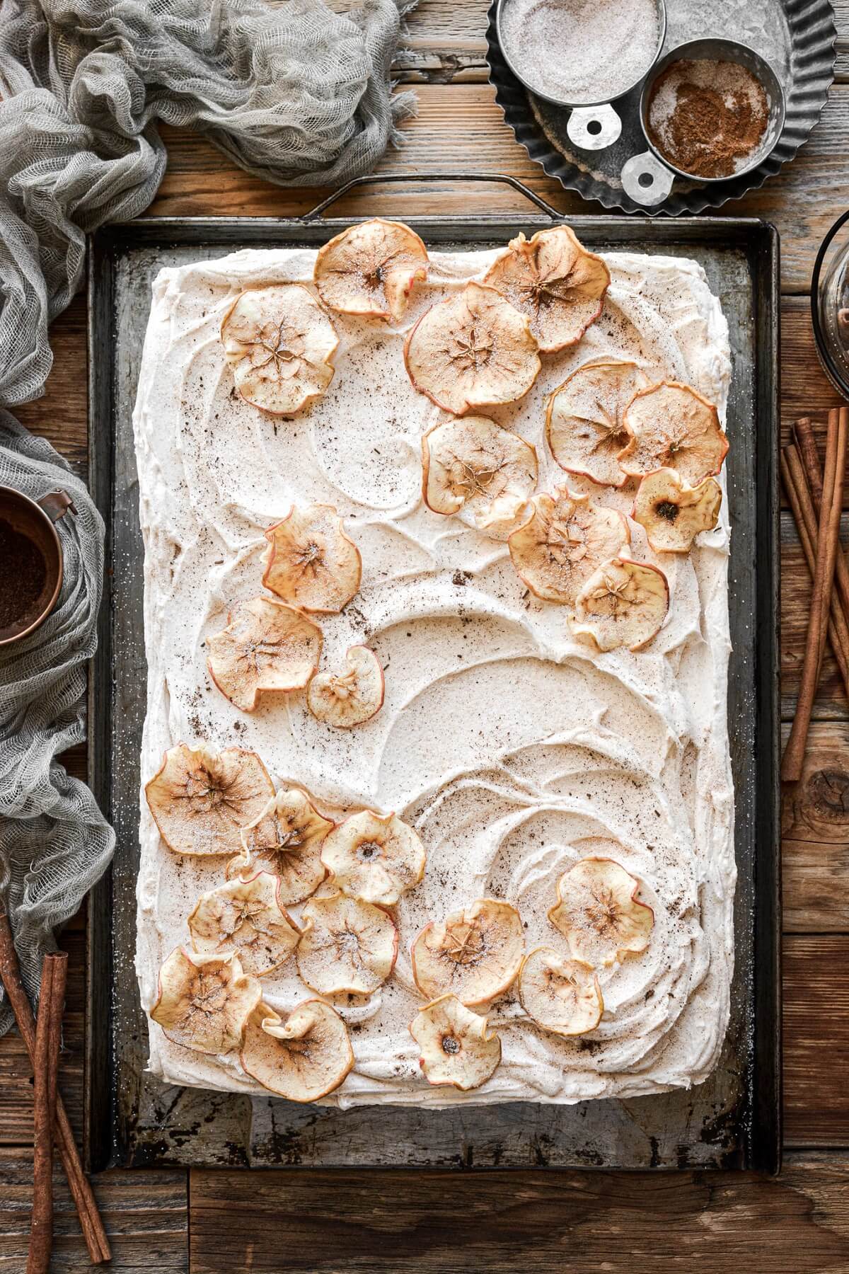 Cinnamon apple cider sheet cake decorated with dried apple slices.