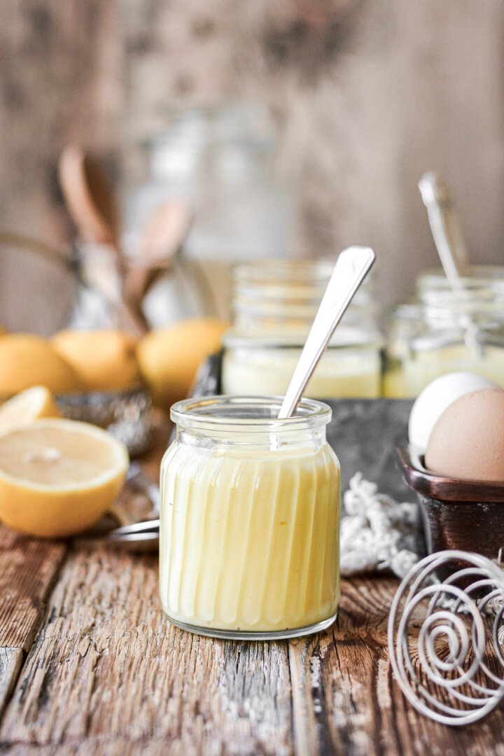 Lemon pudding in a glass jar with a silver spoon.