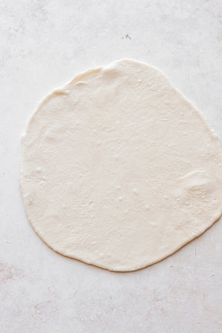 Tortilla dough rolled out thinly.
