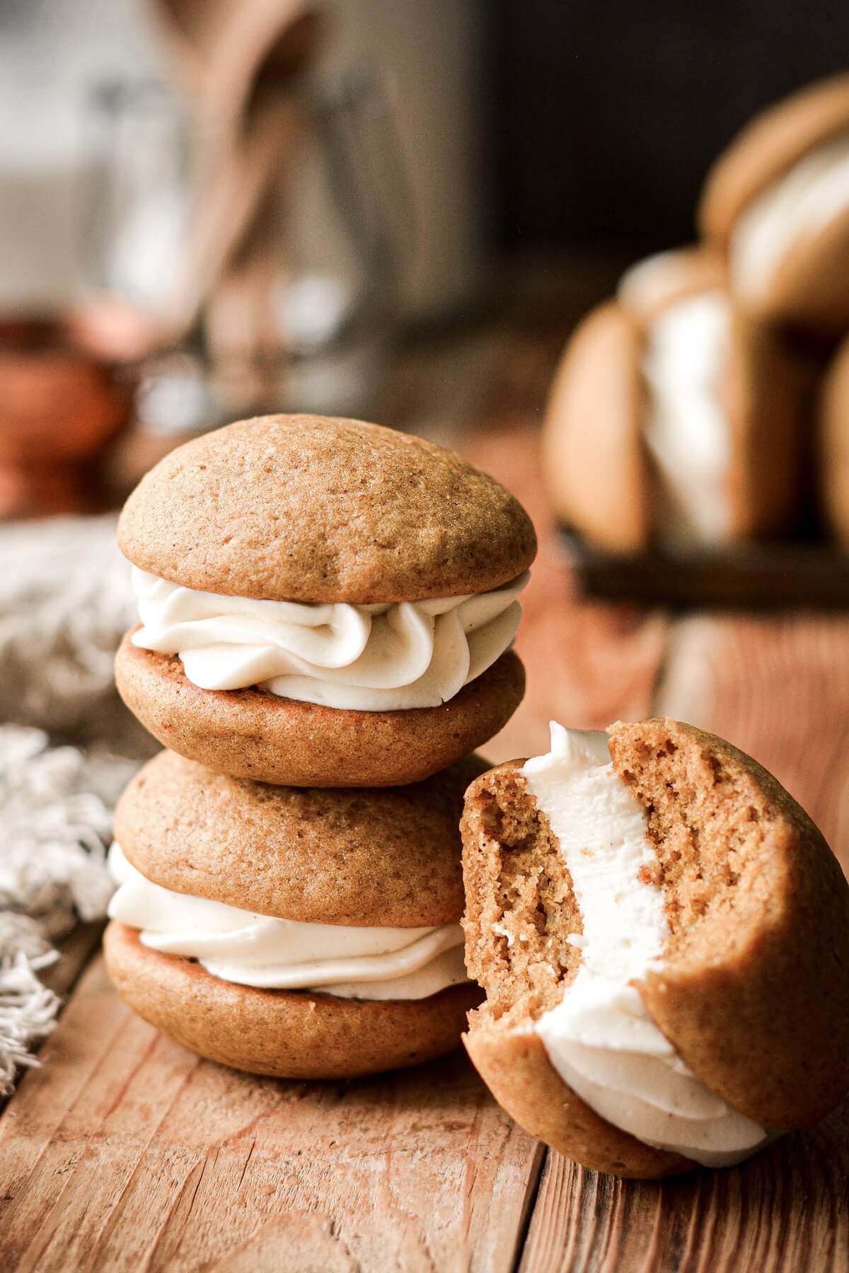 Pumpkin whoopie pies, one with a bite taken.