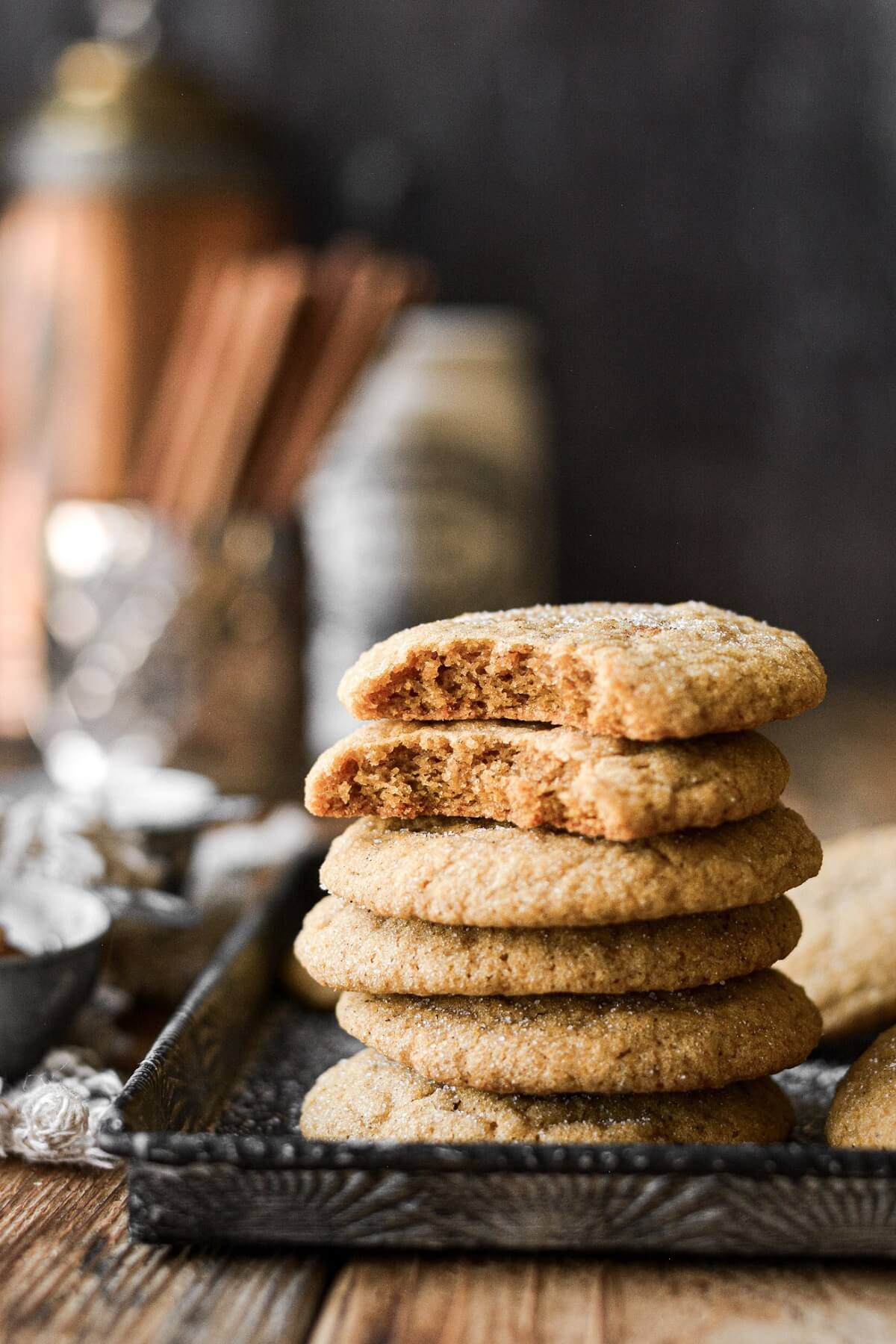 Stack of pumpkin cookies, two with a bite taken.