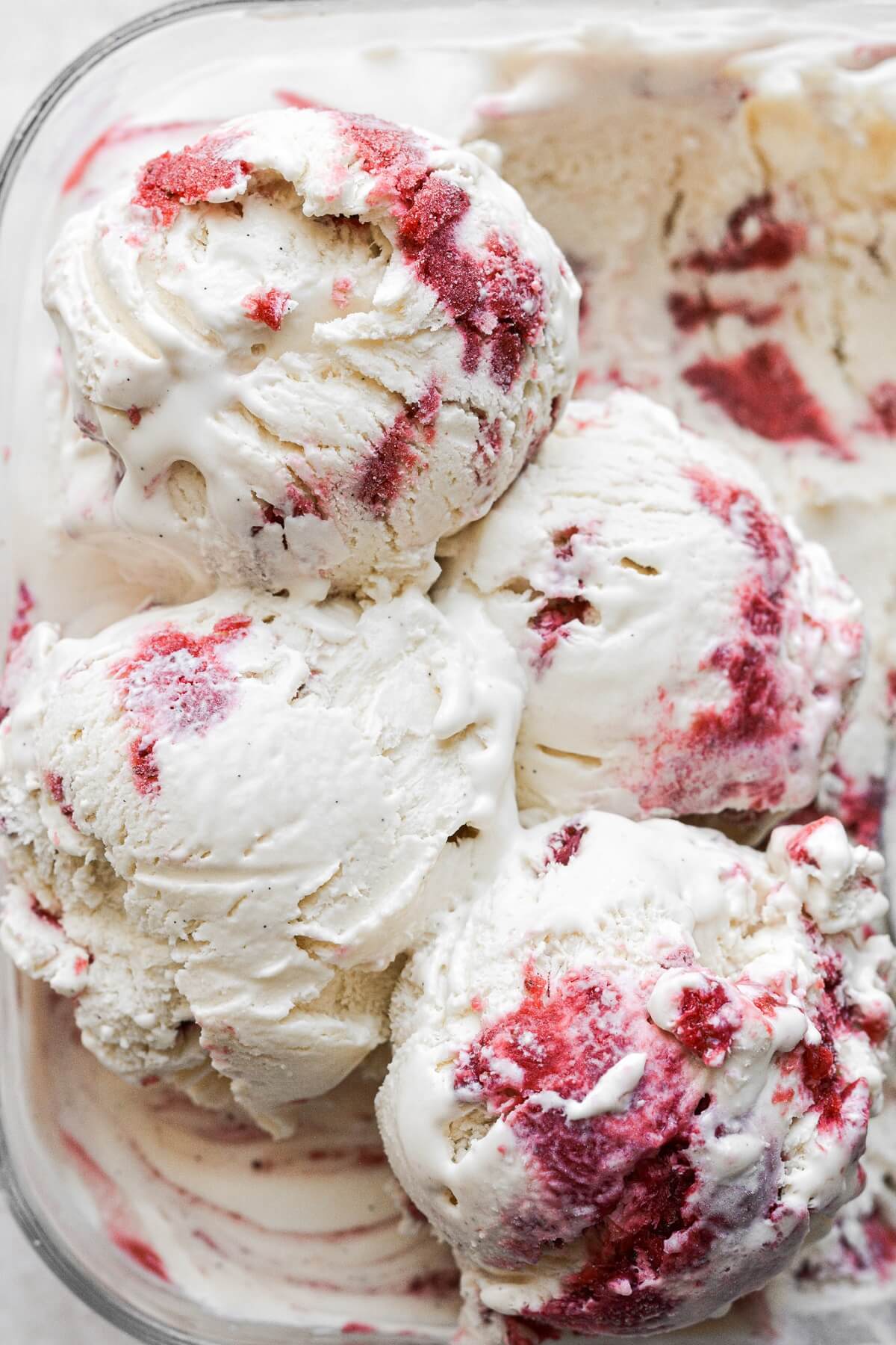 Scoops of vanilla malted milk ice cream with strawberry swirl.