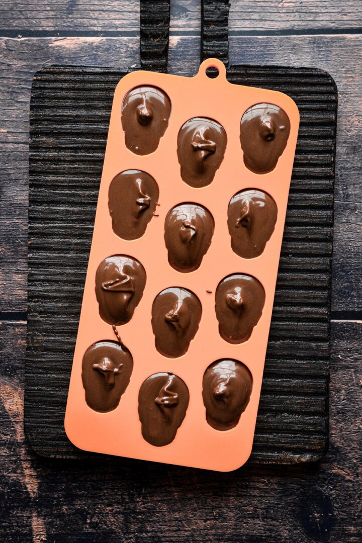 Melted chocolate in a silicone mini skulls mold.