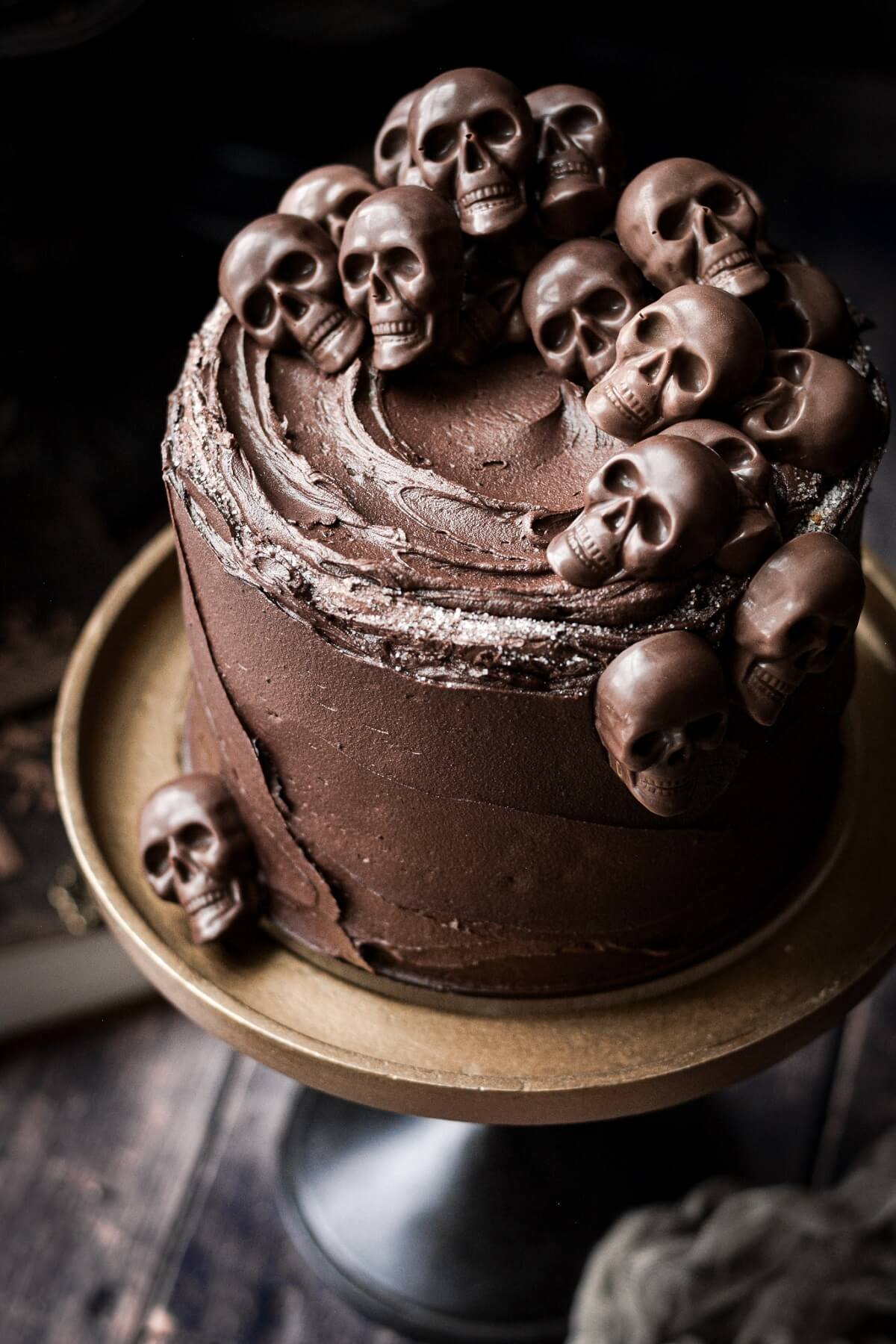 Mini chocolate skulls piled on top of a Halloween cake.