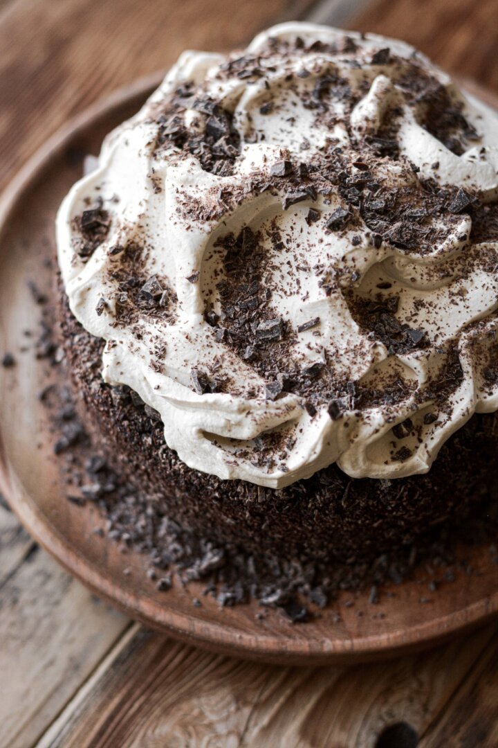 Mocha whipped cream and chopped chocolate on a chocolate cake.