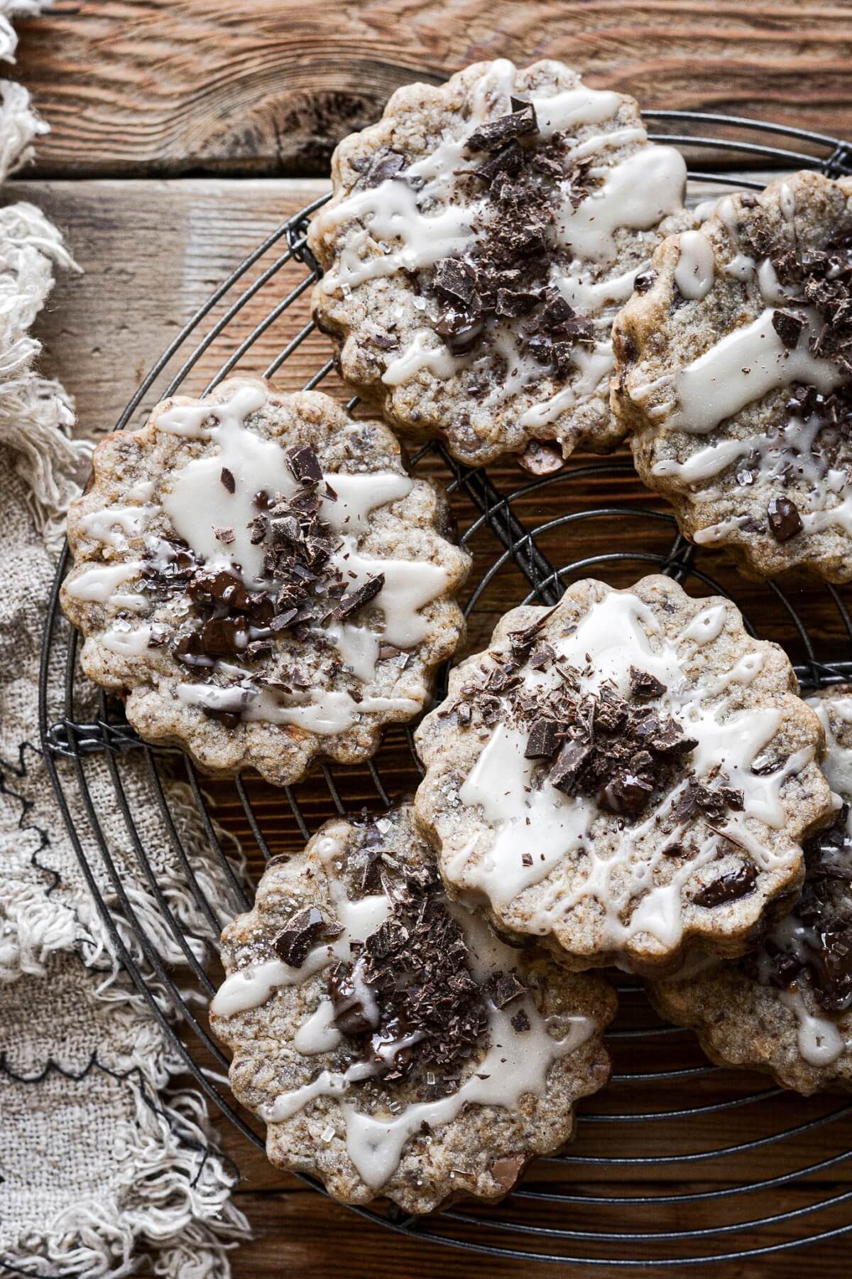 Chocolate chunk shortbread cookies with vanilla icing and chopped chocolate.