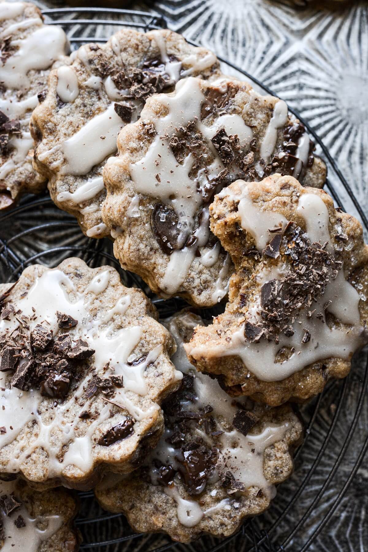 Chocolate chunk shortbread cookies with vanilla icing and chopped chocolate.