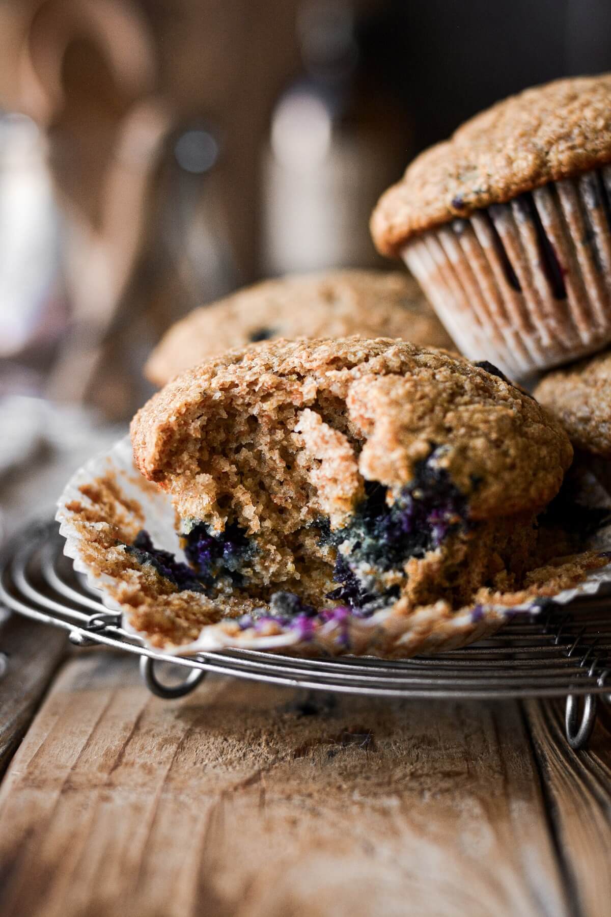 A maple blueberry bran muffin with a bite taken.