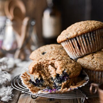 Maple blueberry bran muffins, one with a bite taken.