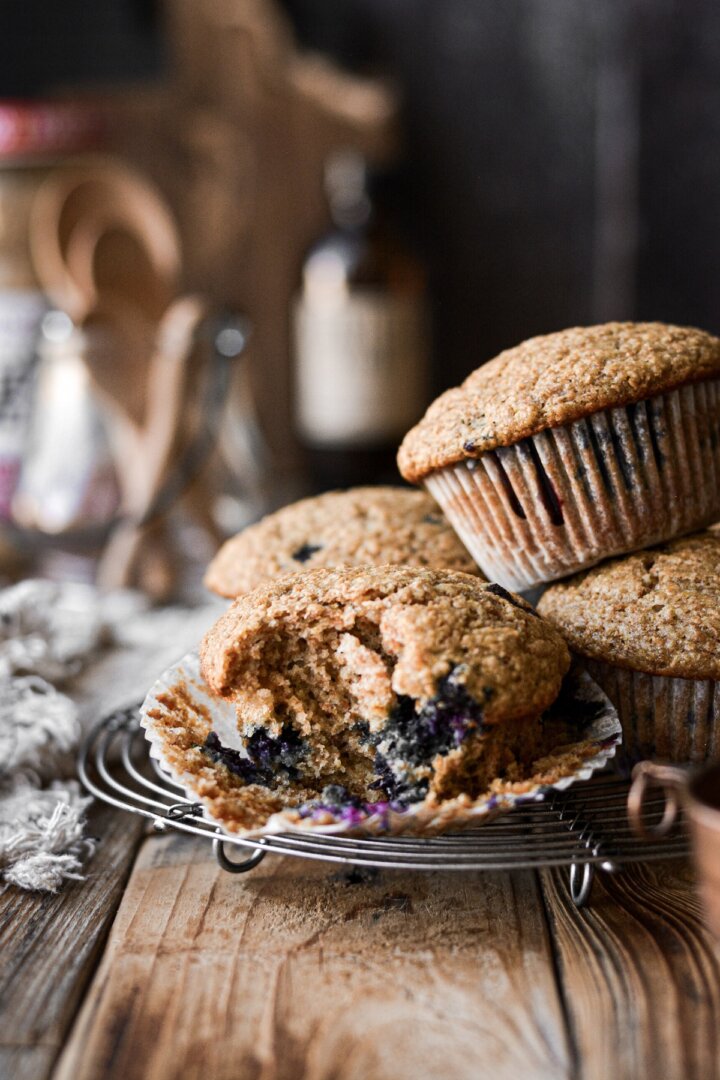 Maple blueberry bran muffins, one with a bite taken.