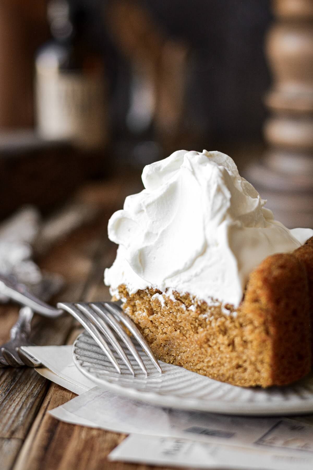 A piece of pumpkin cake with whipped cream.