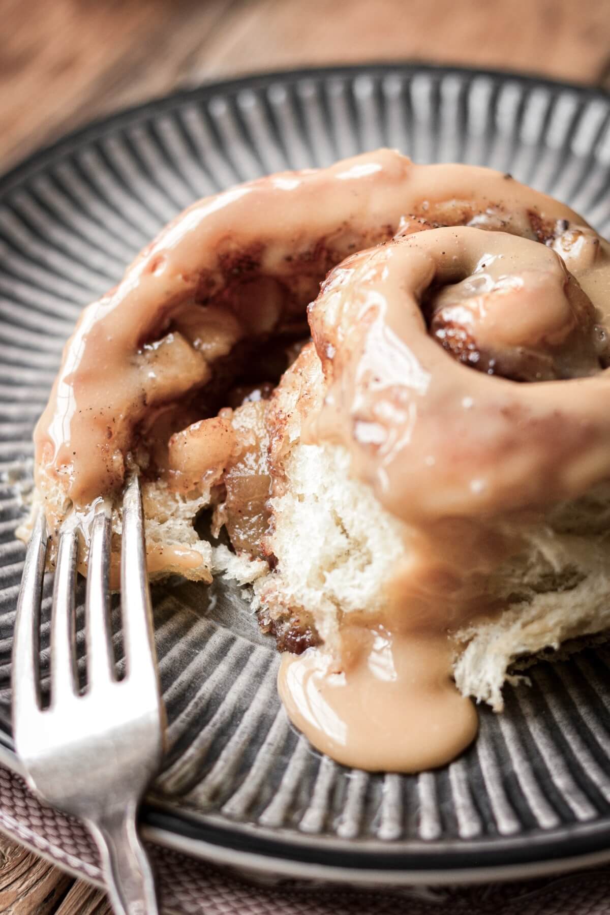 Apple pie cinnamon roll unrolled to show the filling inside.