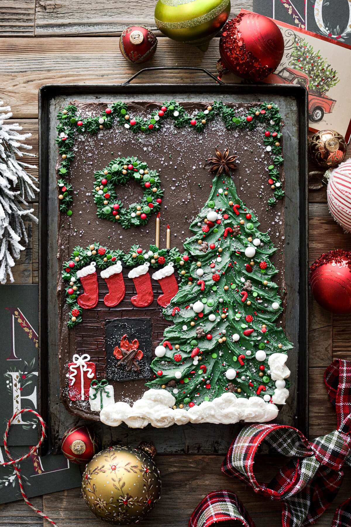 Christmas tree sheet cake with a fireplace, stockings, wreath and garland.