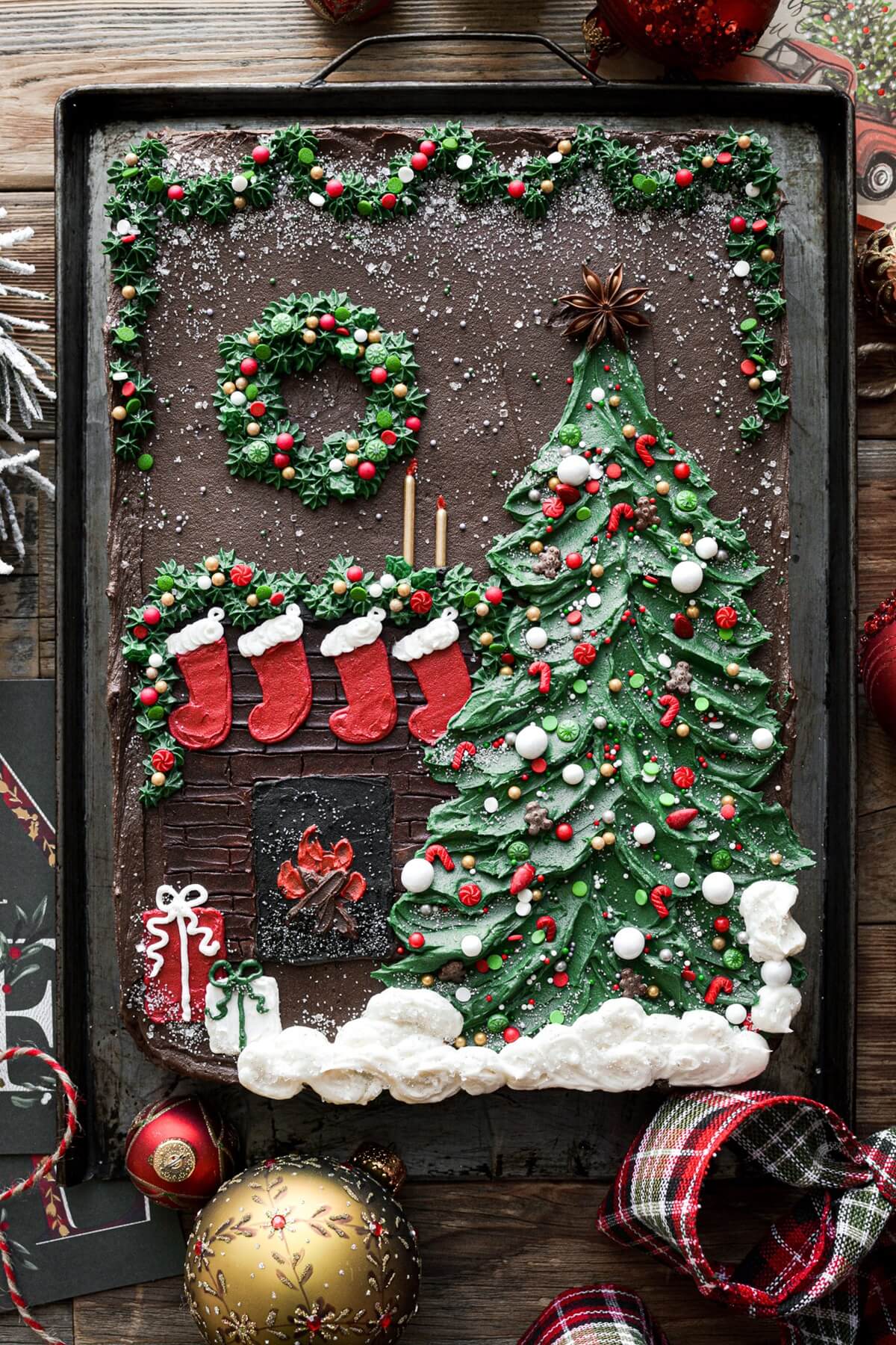 Christmas tree sheet cake with a fireplace, stockings, wreath and garland.