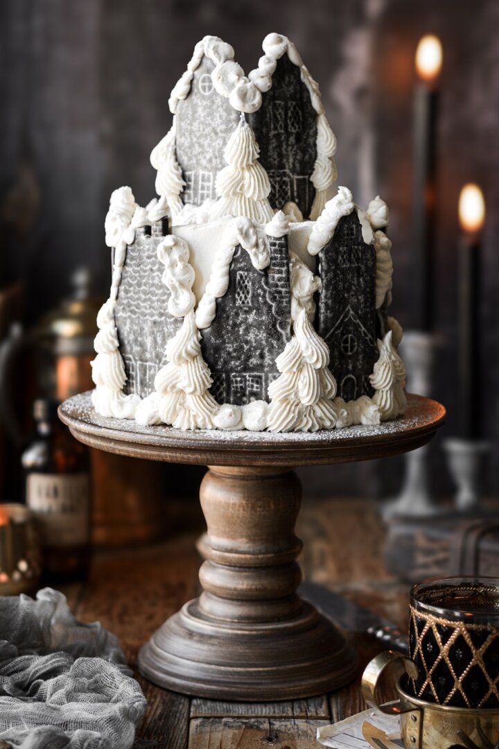 Hogsmeade village cake on a wooden cake stand.