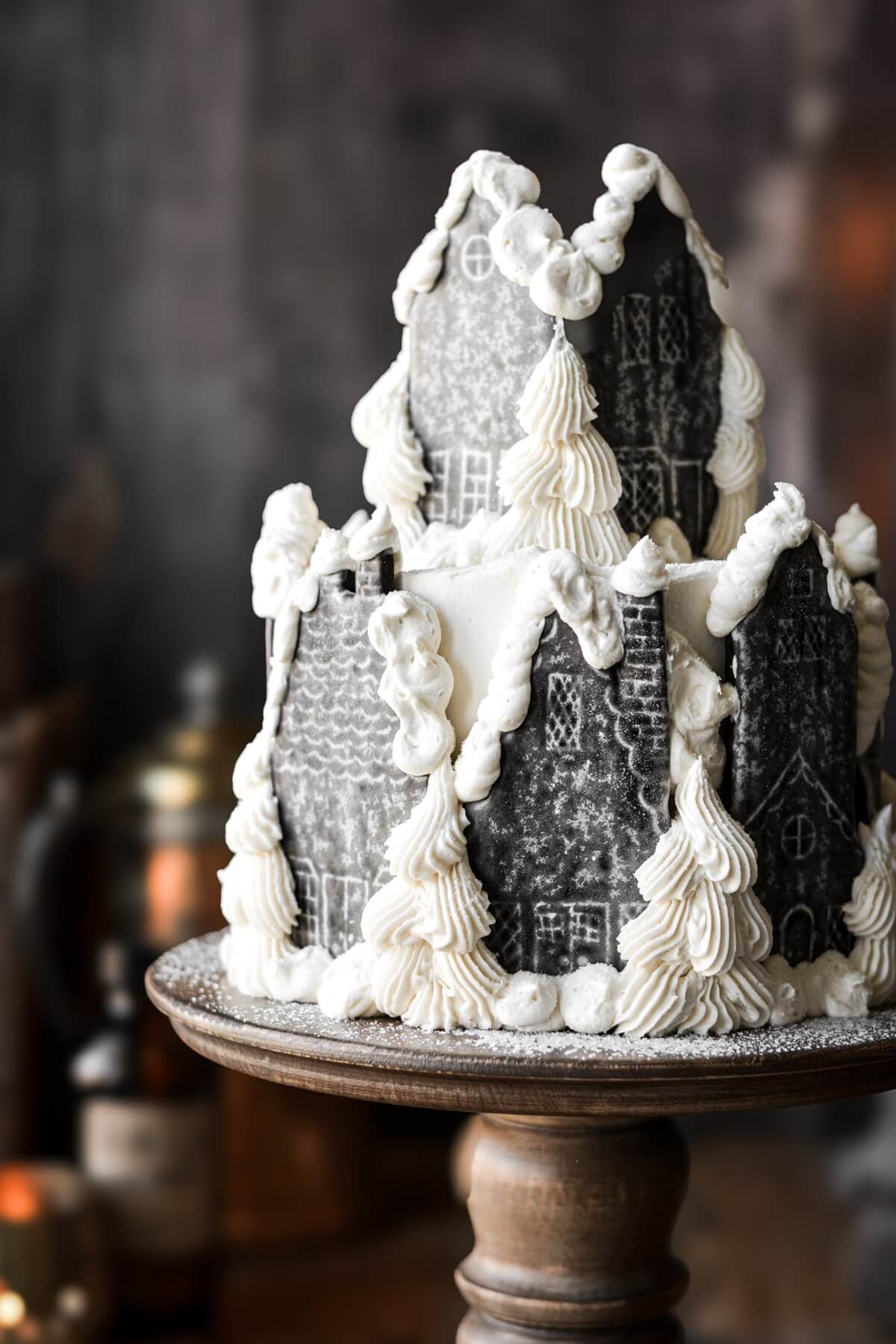 Hogsmeade village cake with chocolate cookie houses and piped buttercream trees and snowdrifts.