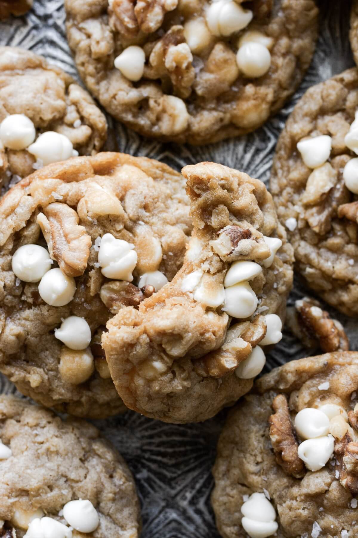 Maple walnut white chocolate chip oatmeal cookie with a bite taken.