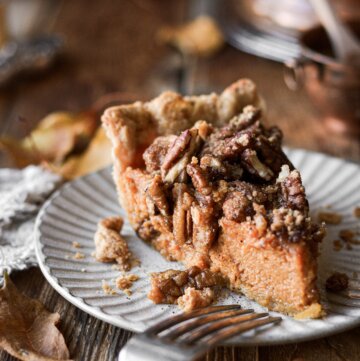 A slice of pecan pie topped with pecans.