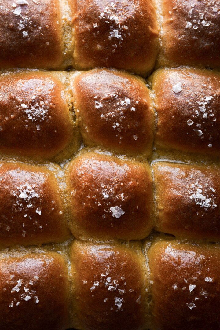 Sweet potato dinner rolls with butter and flaky salt.