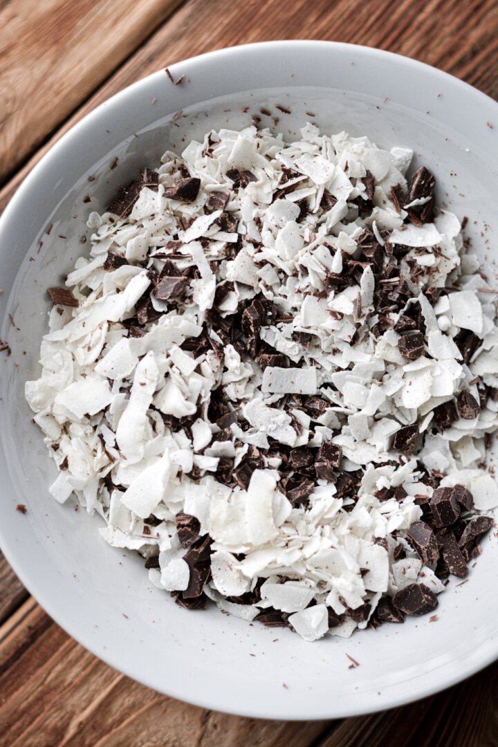 Bowl of coconut flakes and chopped chocolate.