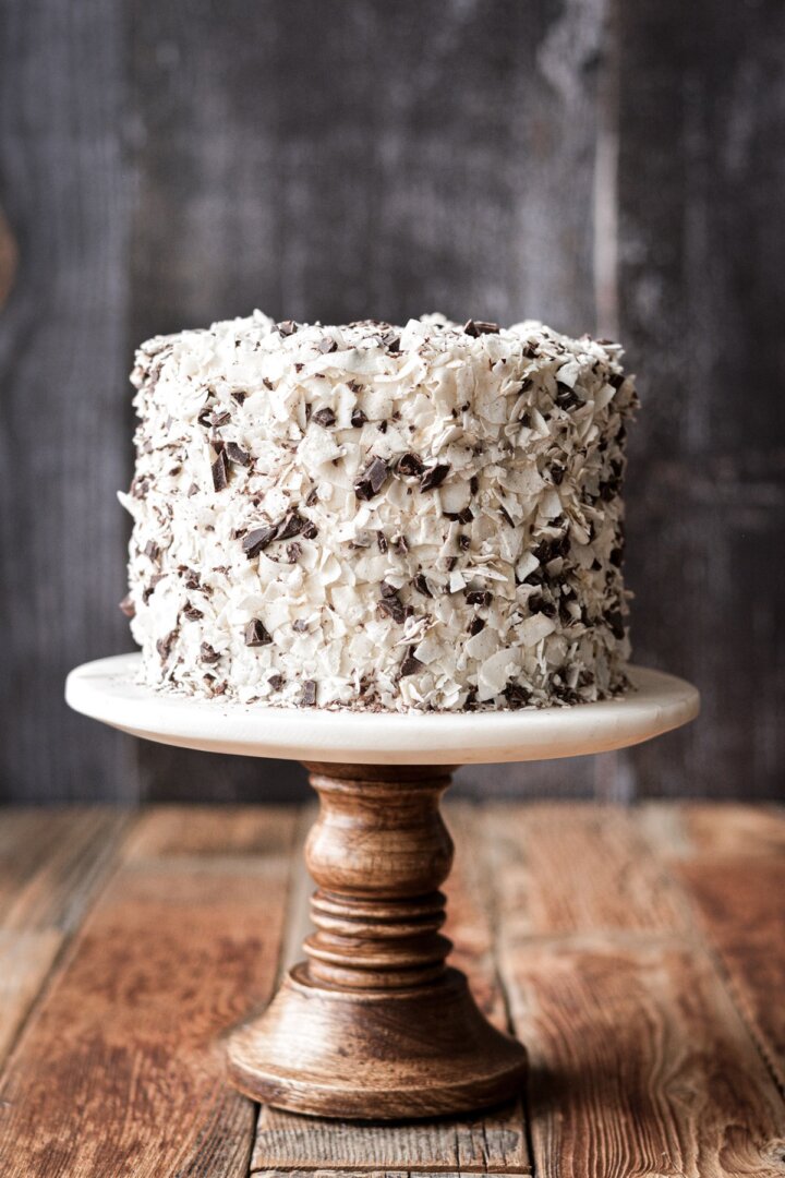 Coconut flakes and chopped chocolate pressed all over a cake.