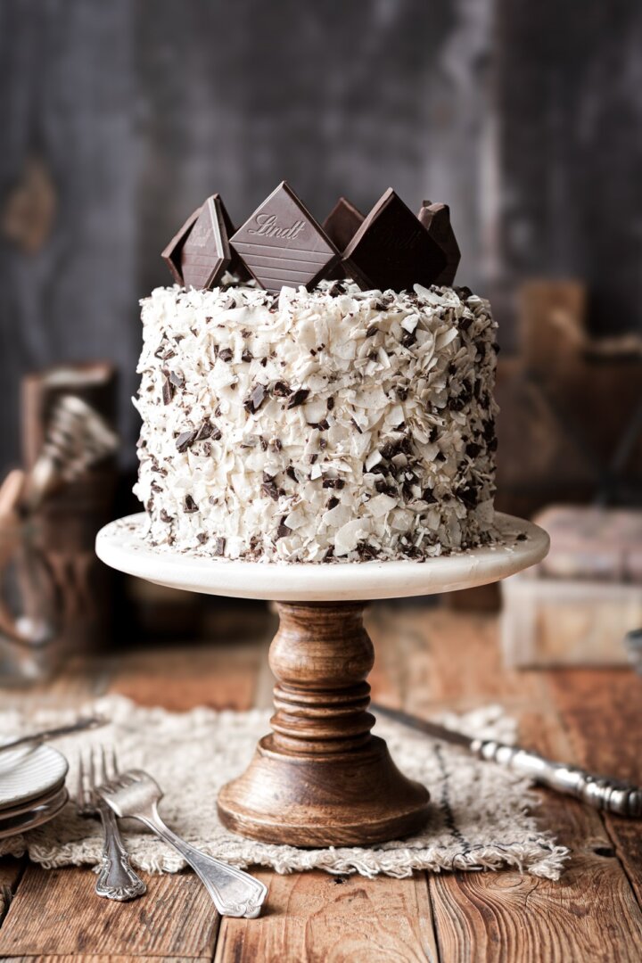Chocolate coconut cake topped with chocolate squares.