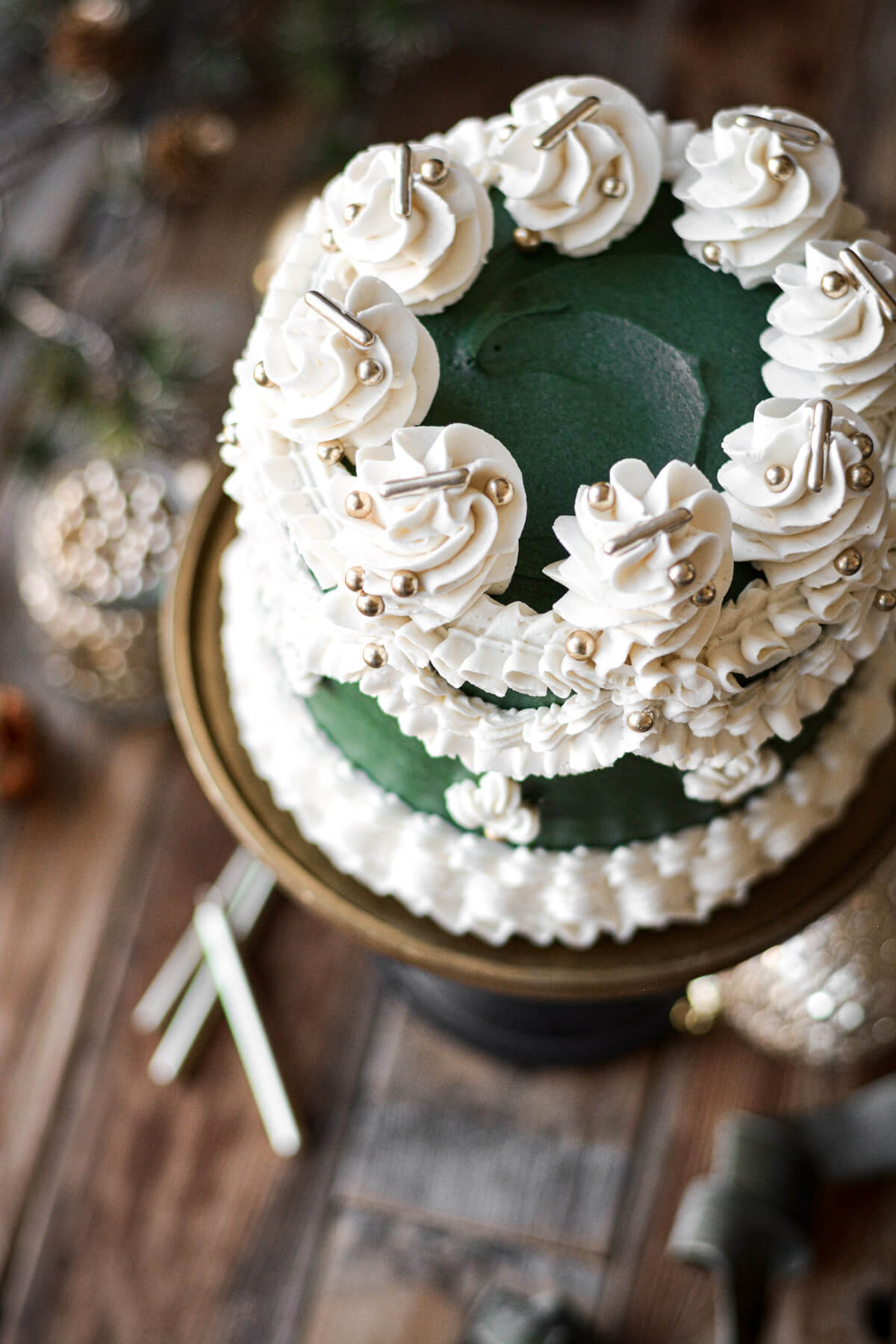 Green and white Christmas cake with gold dragees.