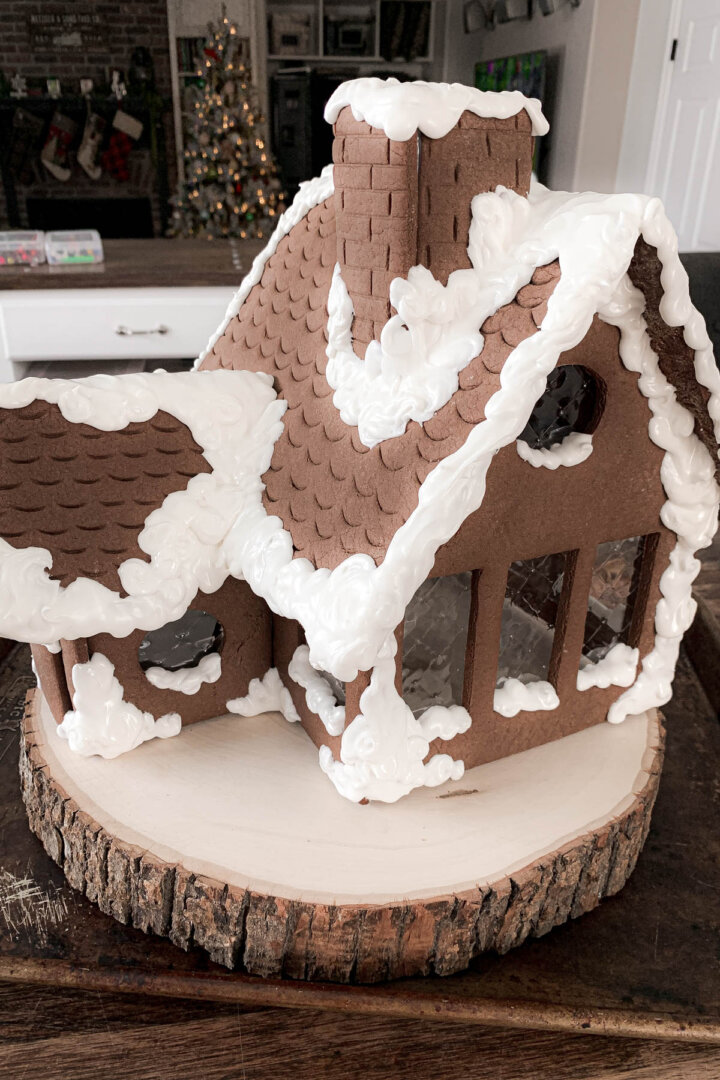 Step 6 for decorating a gingerbread house with royal icing snow.