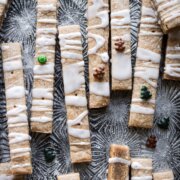 Gingerbread shortbread cookie sticks with lemon icing and Christmas sprinkles.