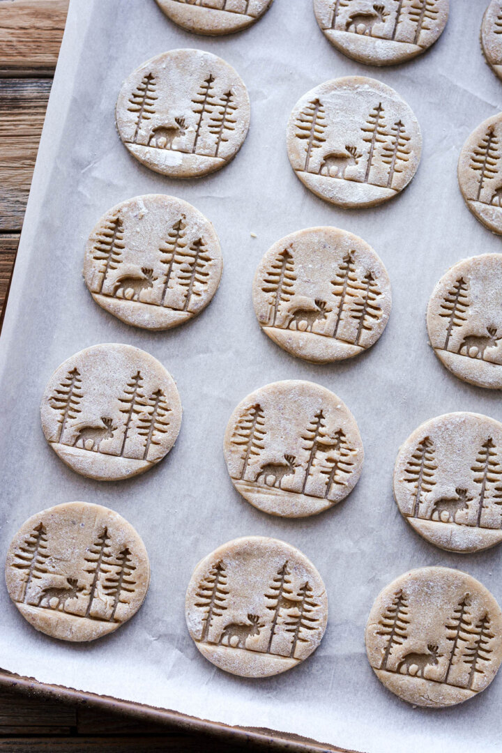 Pressed hazelnut cookies with a moose and trees design.