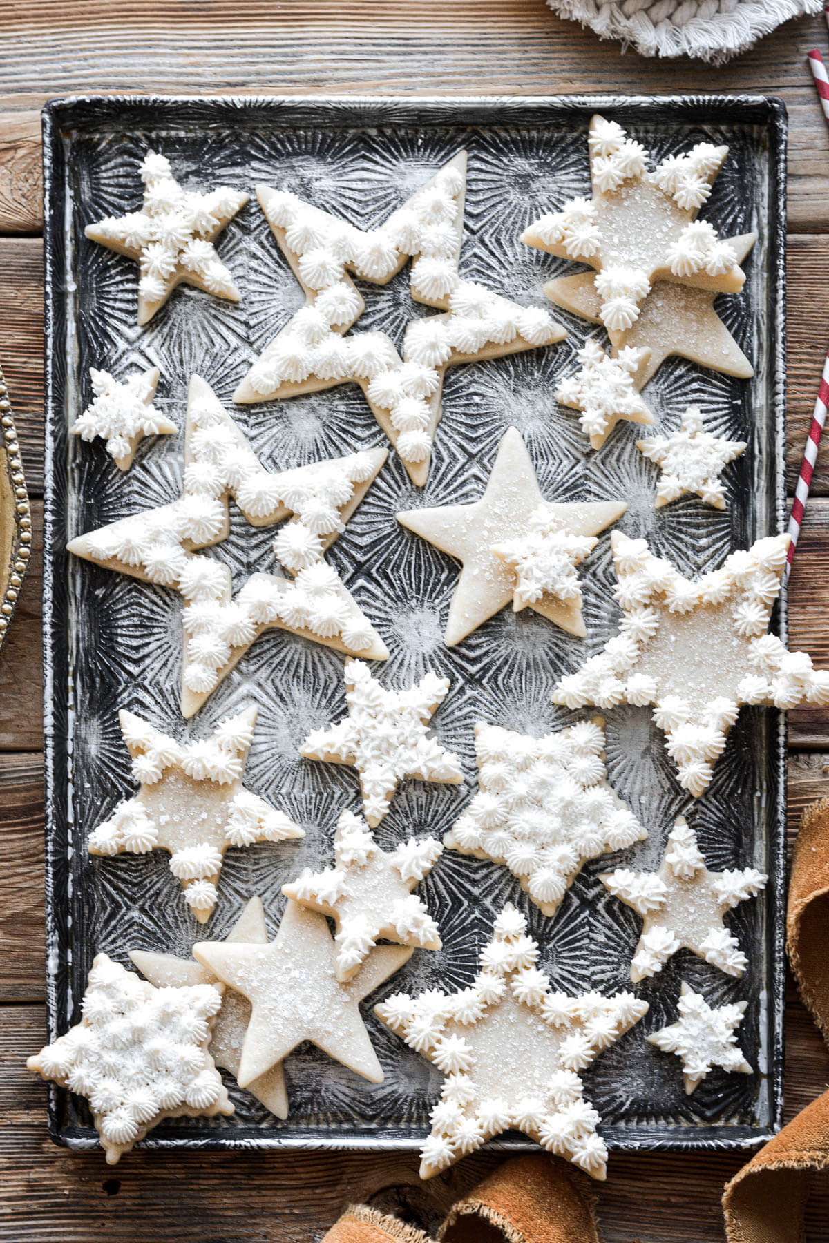 Star shaped Christmas cutout cookies with peppermint buttercream on a baking sheet.
