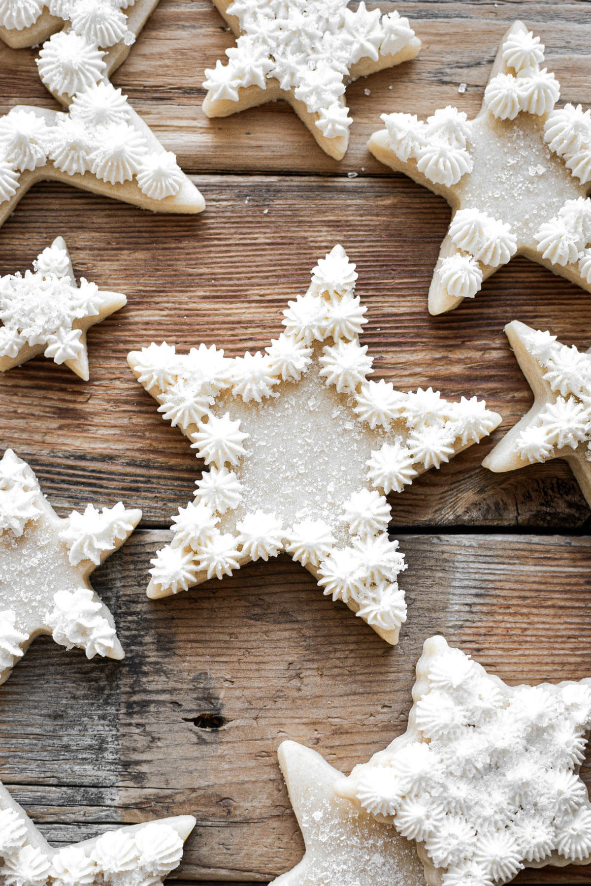 Star shaped cutout Christmas cookies decorated with white peppermint buttercream.