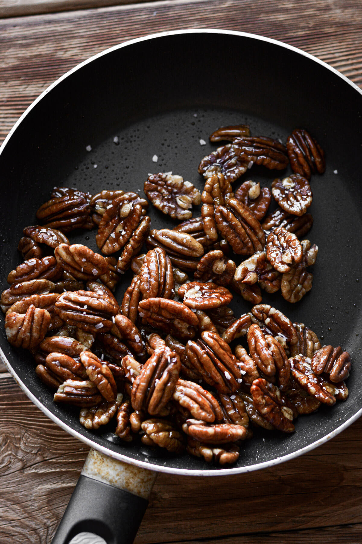 Maple glazed pecans in a skillet.