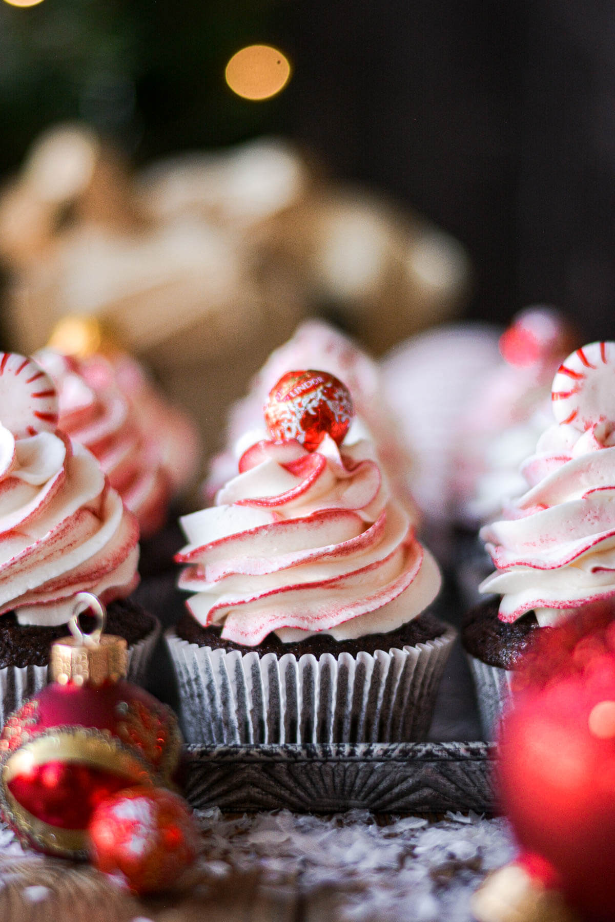 Chocolate peppermint swirl cupcakes topped with peppermints and chocolate balls.