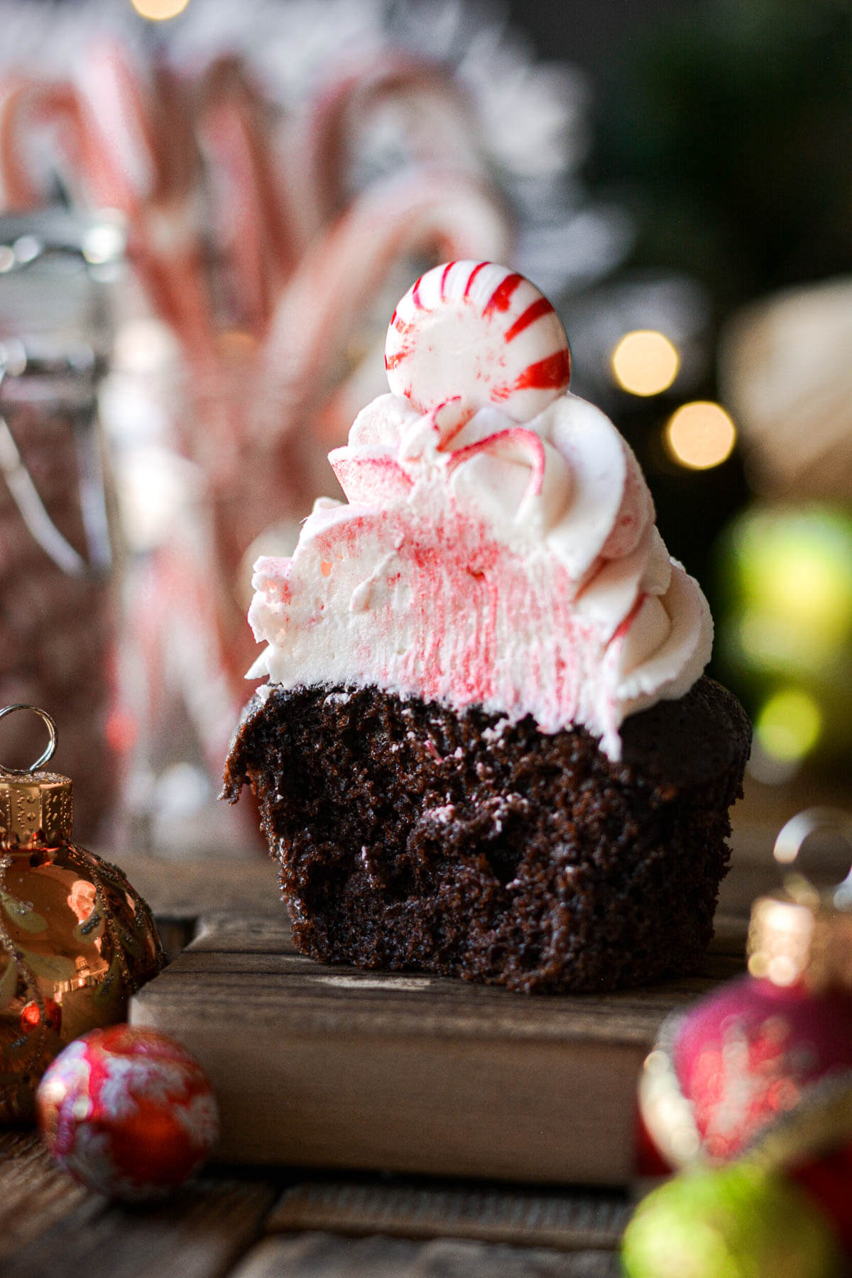 A chocolate peppermint cupcake with a bite taken.