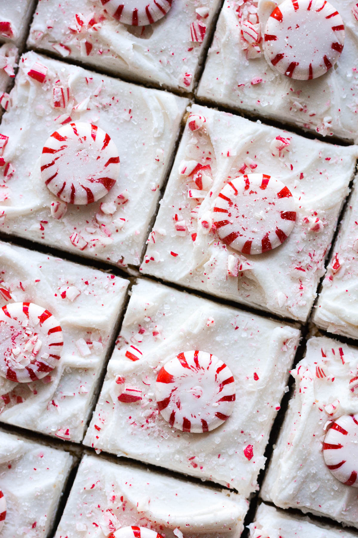 Frosted peppermint blondies, cut in squares and topped with peppermint candy.