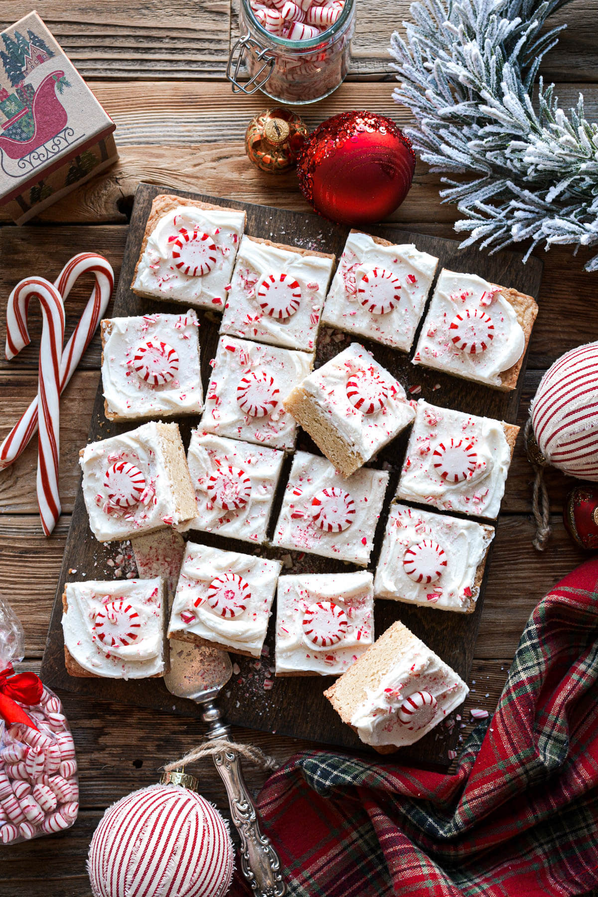 Frosted peppermint blondies, surrounded by Christmas candy and decorations.