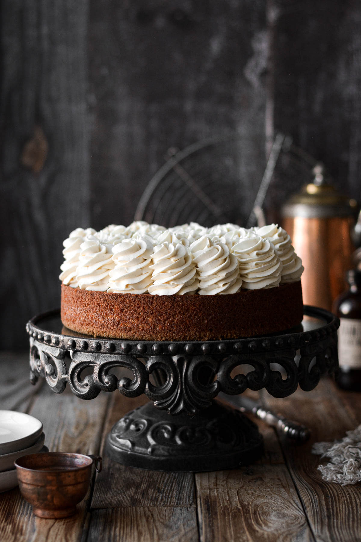 Carrot cake cheesecake on a black cake stand.