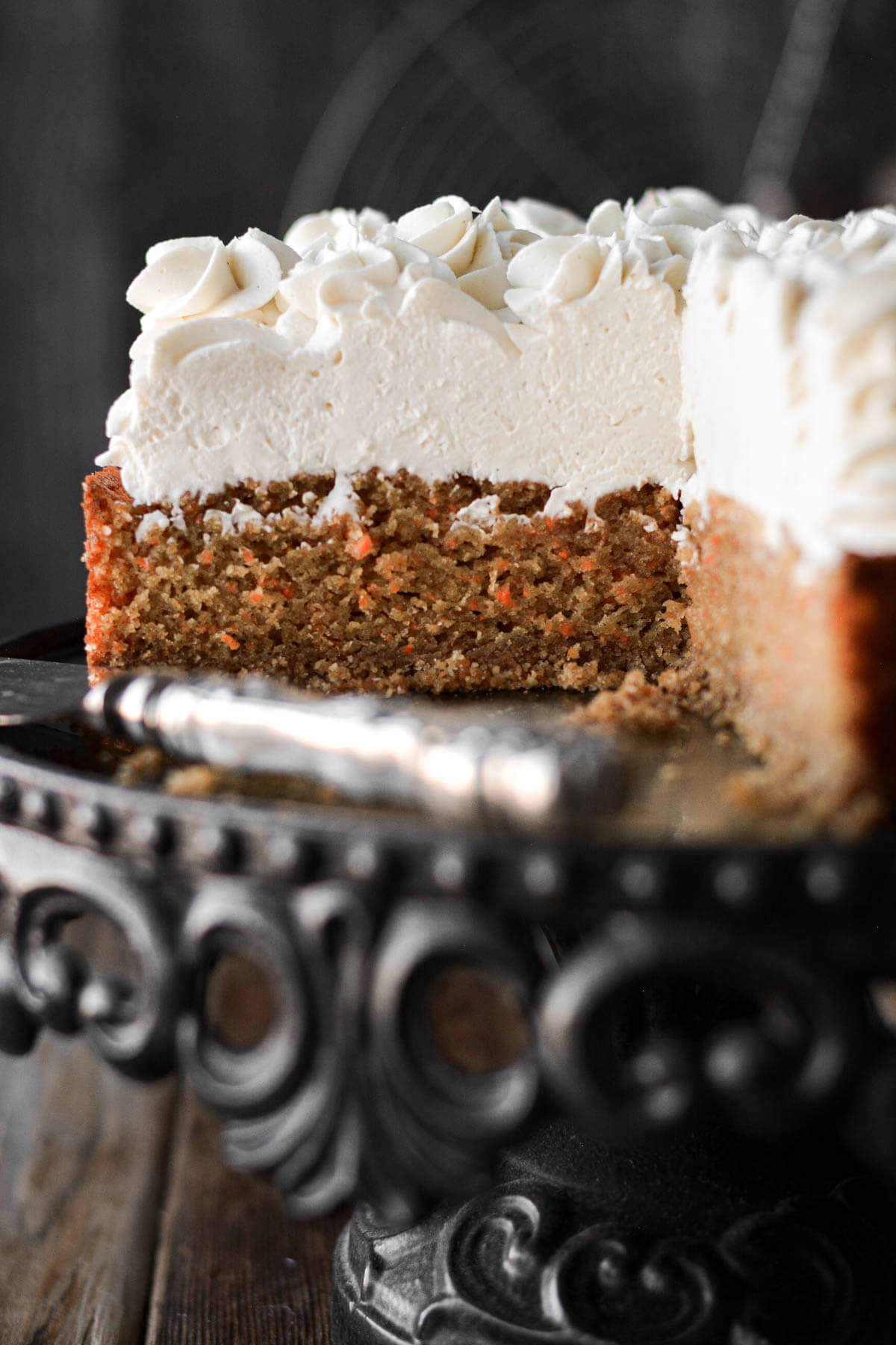 Carrot cake cheesecake with a slice cut.