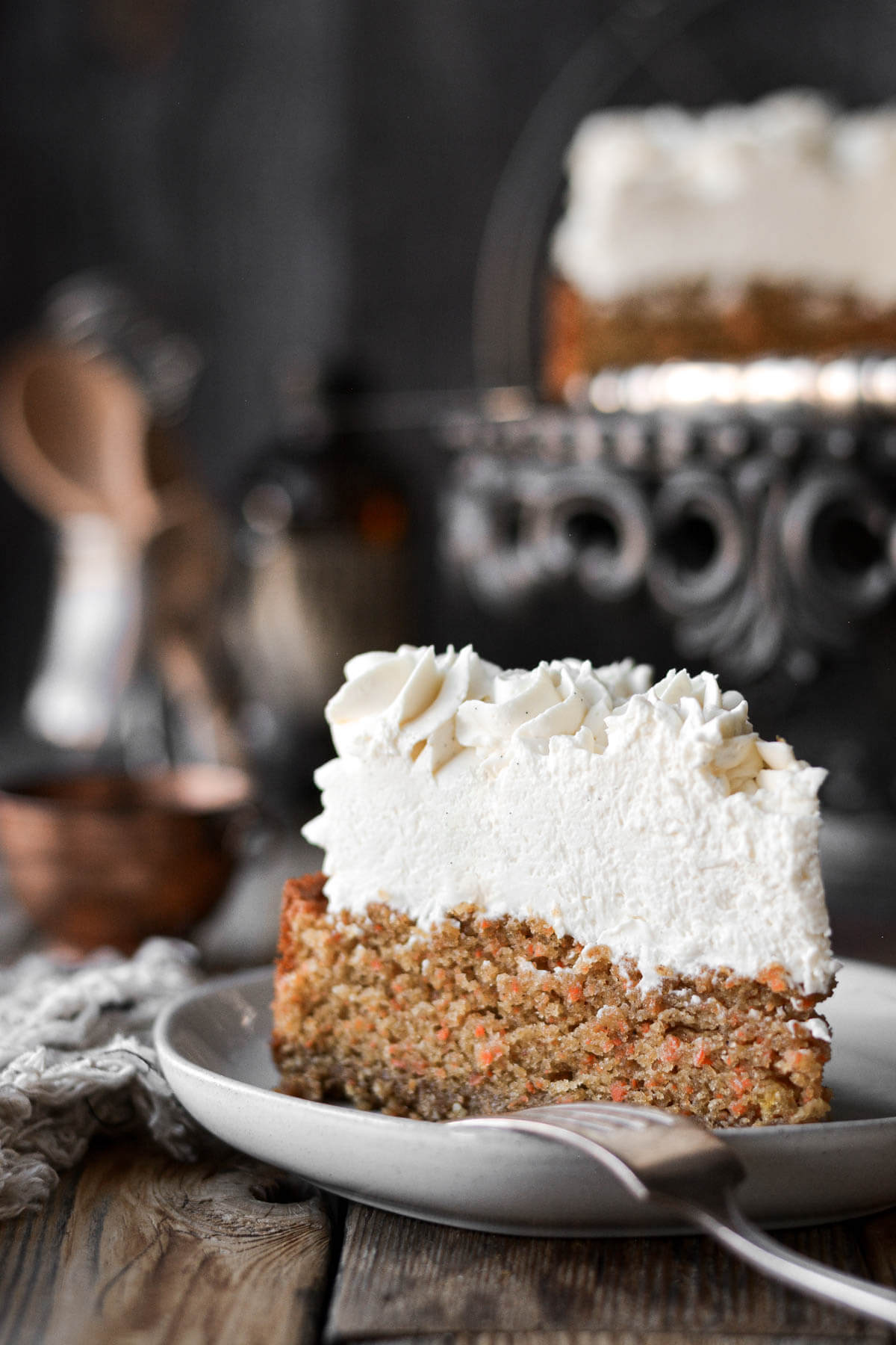 A slice of carrot cake cheesecake on a plate.