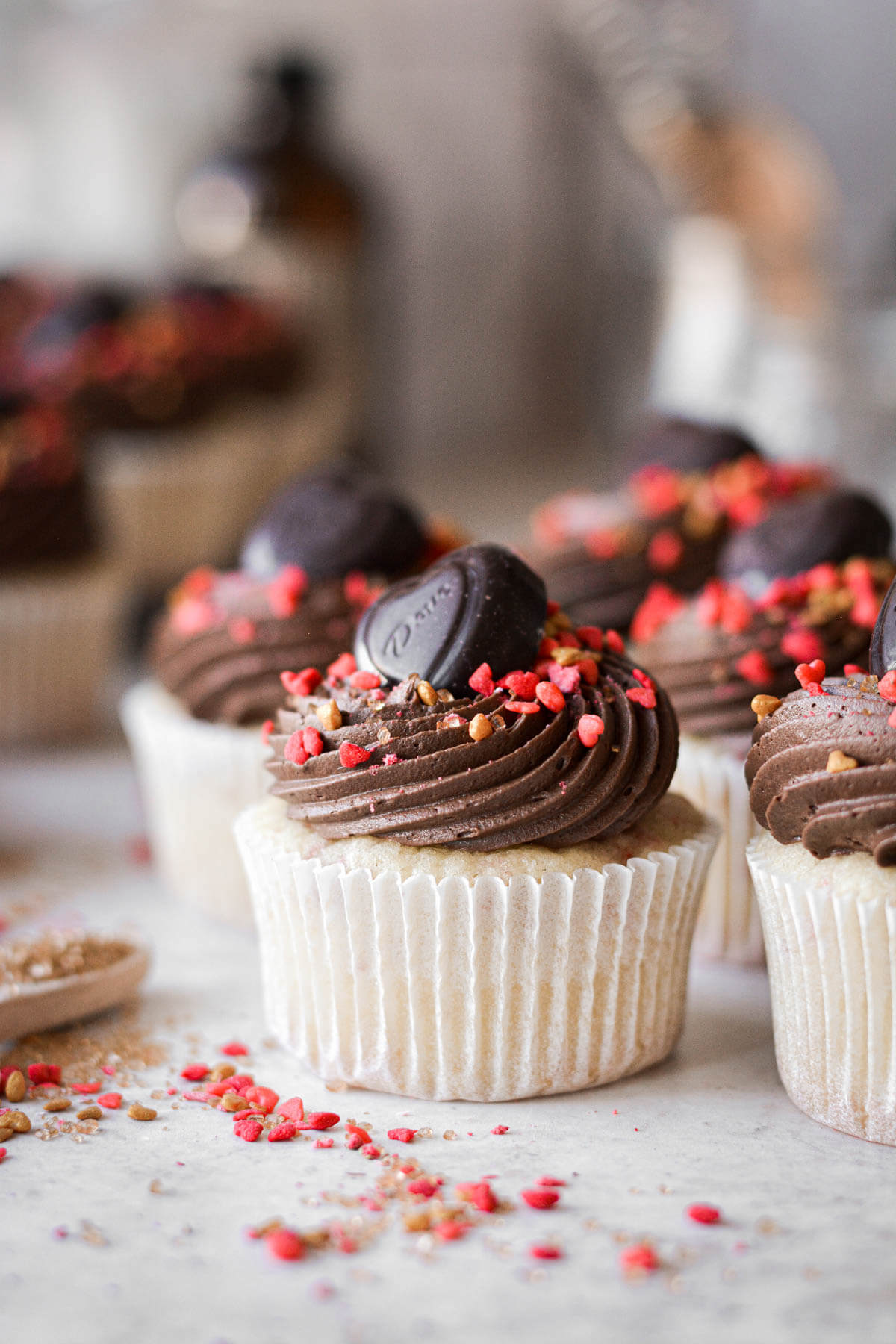 Strawberry chocolate cupcakes with chocolate hearts and red sprinkles.