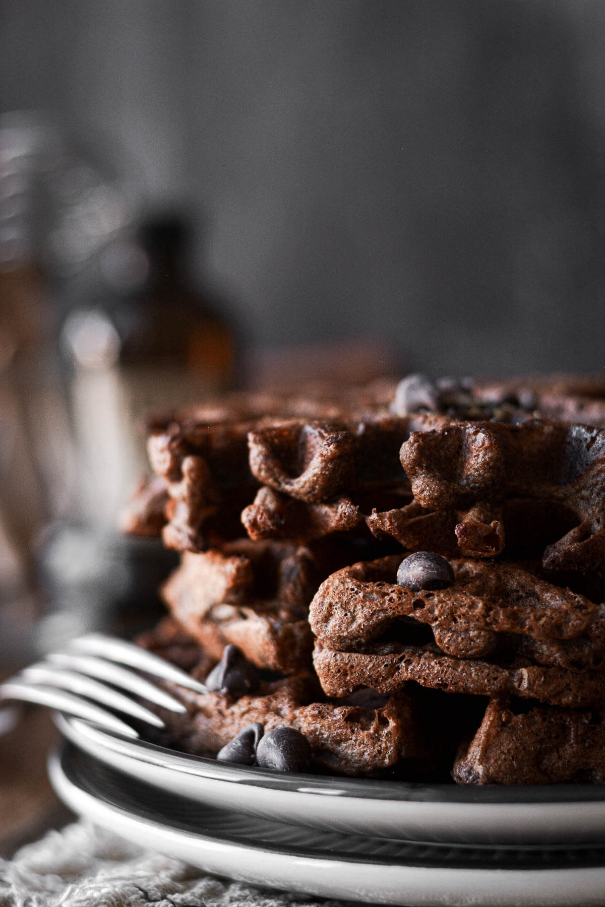Stack of chocolate waffles on a plate.