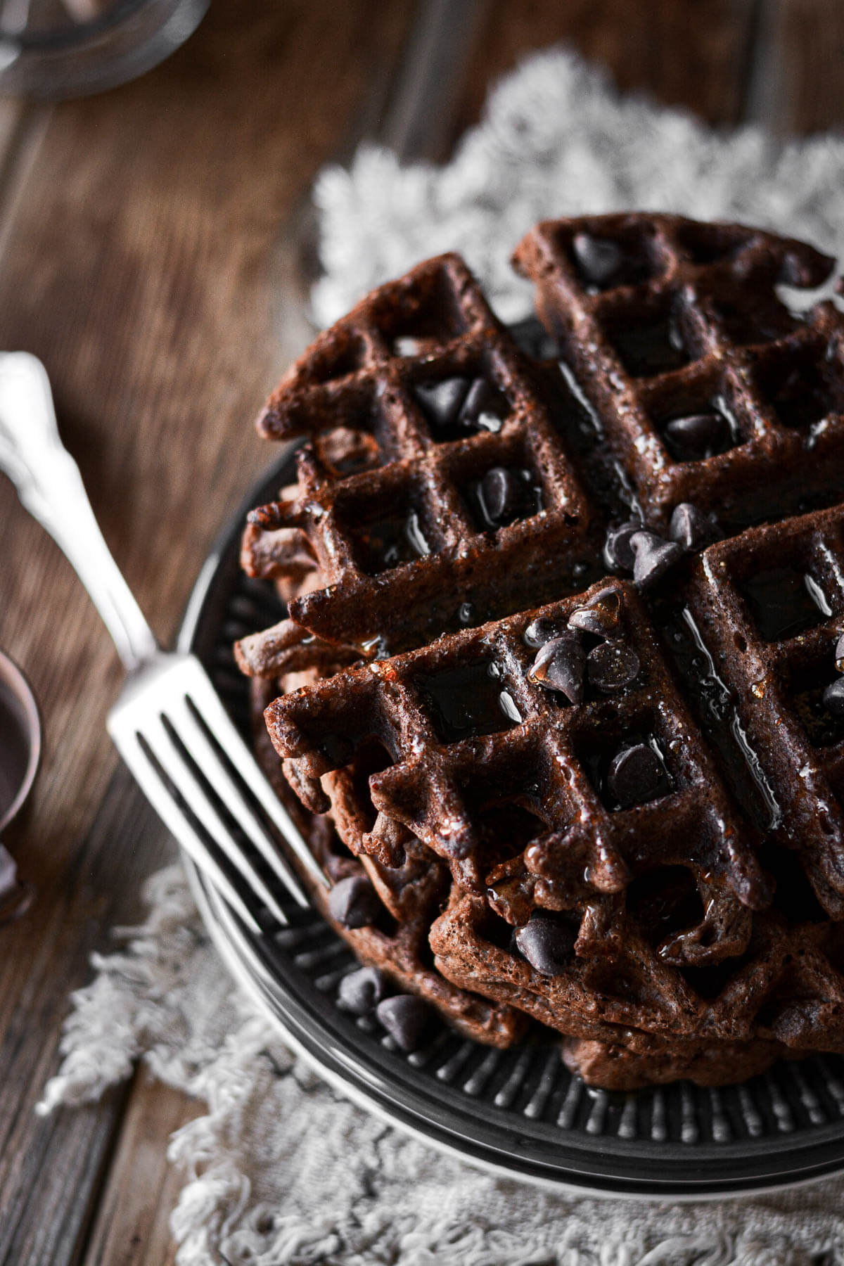 Chocolate waffles with syrup and chocolate chips.