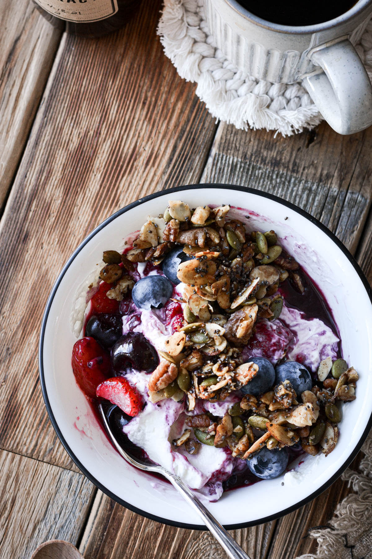A bowl of yogurt and berries topped with granola.